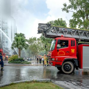 Firefighters and trucks responding to an urban building fire scene.